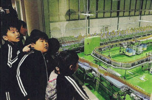 ペットボトル飲料の製造工程を見学する児童たち＝神河町福本